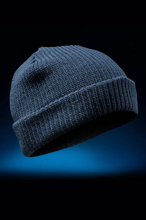 The FXD CP-10 Knit Ribbed Beanie, in dark blue with a folded brim and classic knit construction, is showcased against a black and blue gradient background.