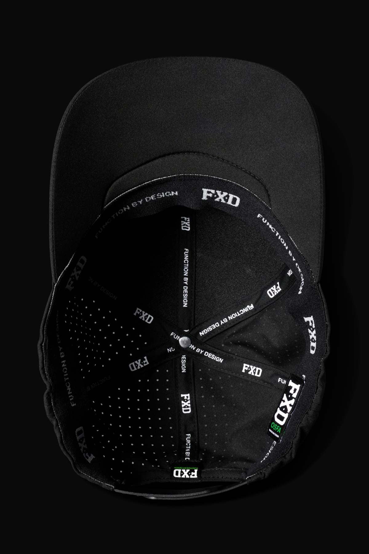 The FXD CP-12 Tech Baseball Cap, black from above, showcases a detailed interior with "FXD" and "FUNCTION BY DESIGN" in white along the seams of its predominantly black lining. It features lightweight, quick-drying performance polyester for structured style.