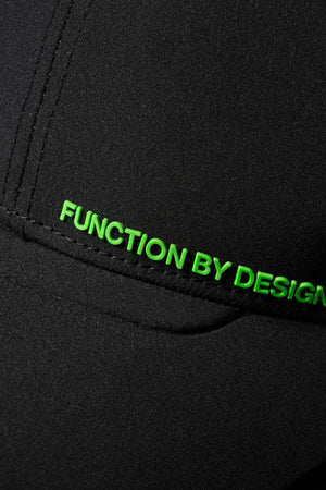 Close-up of the black FXD CP-12 Tech Baseball Cap with "FUNCTION BY DESIGN" stitched in bright green along a seam. Features an adjustable snap-back for the perfect fit.