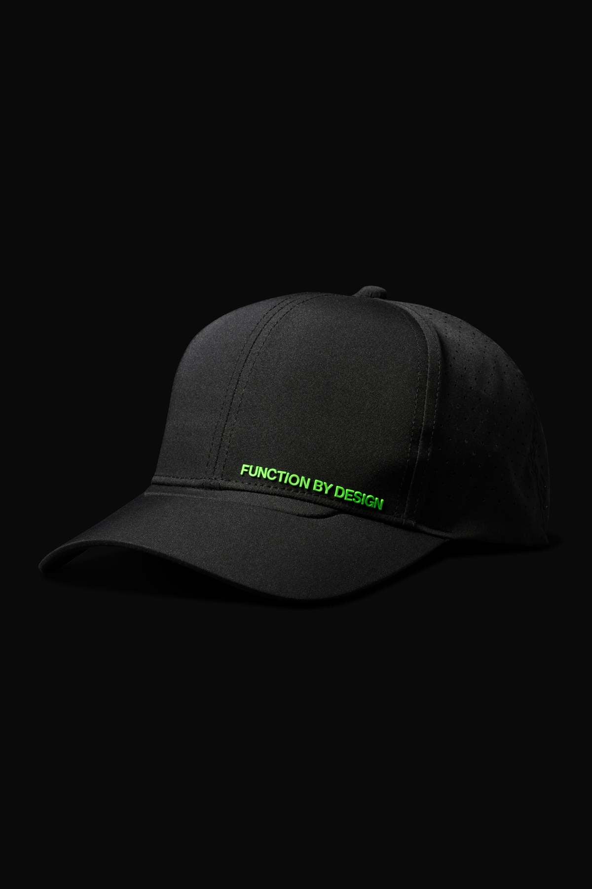 The FXD CP-12 Tech Baseball Cap is black with green "FUNCTION BY DESIGN" text on the front, has an adjustable snap-back, and is shown against a solid black background.