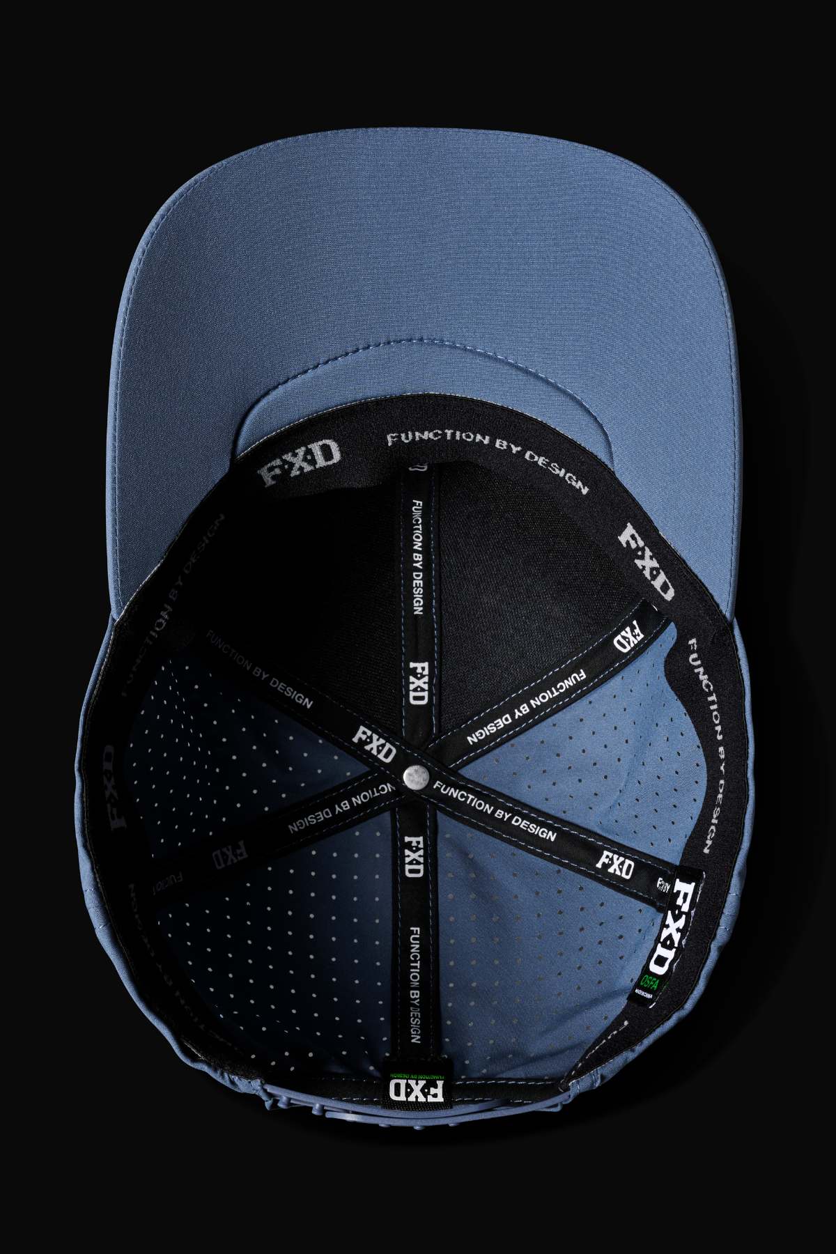 The FXD CP-12 Tech Baseball Cap is shown upside down on a black background, revealing its interior. It features a black inner band with "FXD FUNCTION BY DESIGN" text along the seams, crafted from breathable, quick-drying polyester.