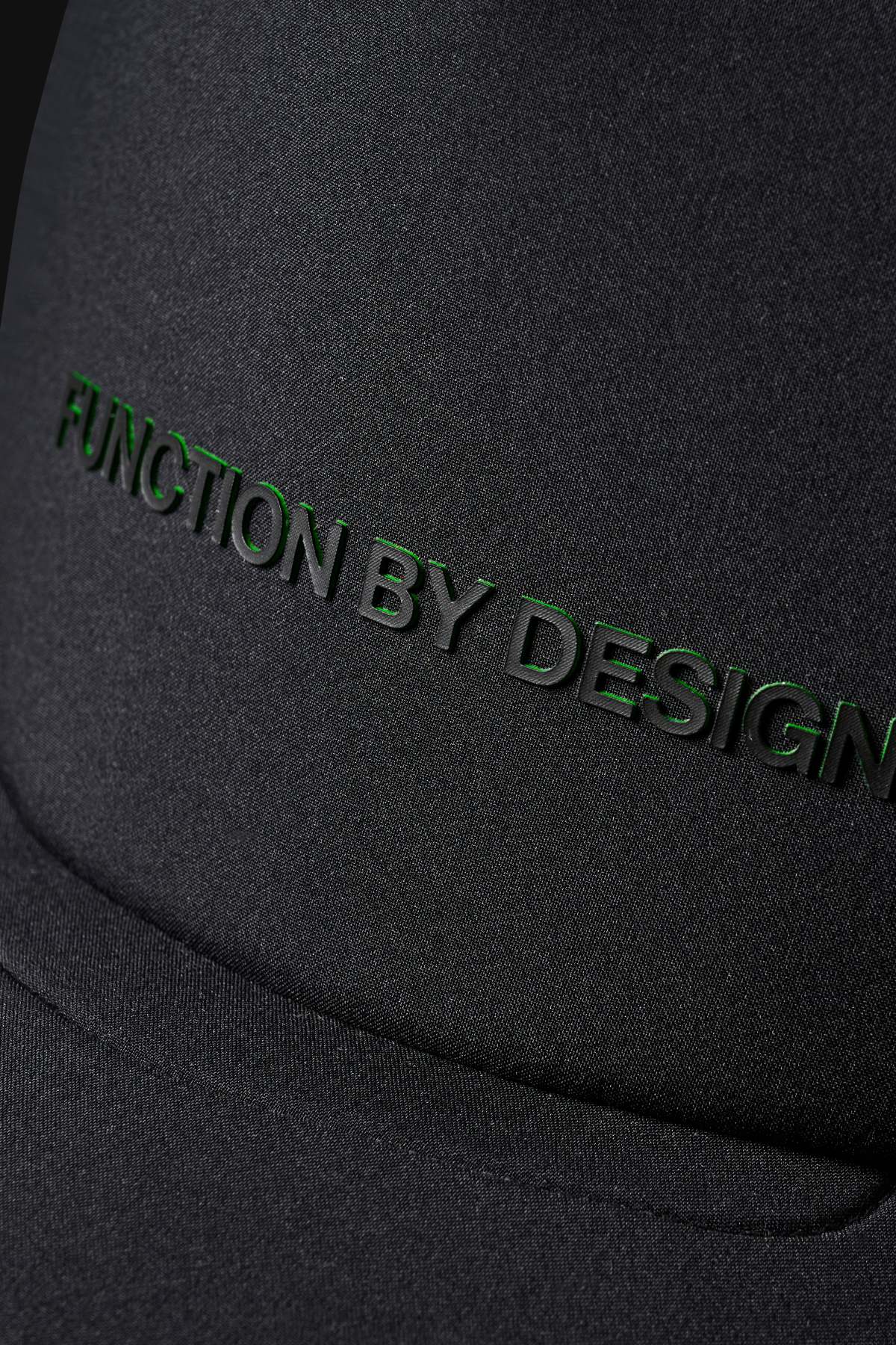 Close-up of the FXD CP-13 Trucker Cap’s black, breathable fabric with raised black “FUNCTION BY DESIGN” lettering embossed on the surface.