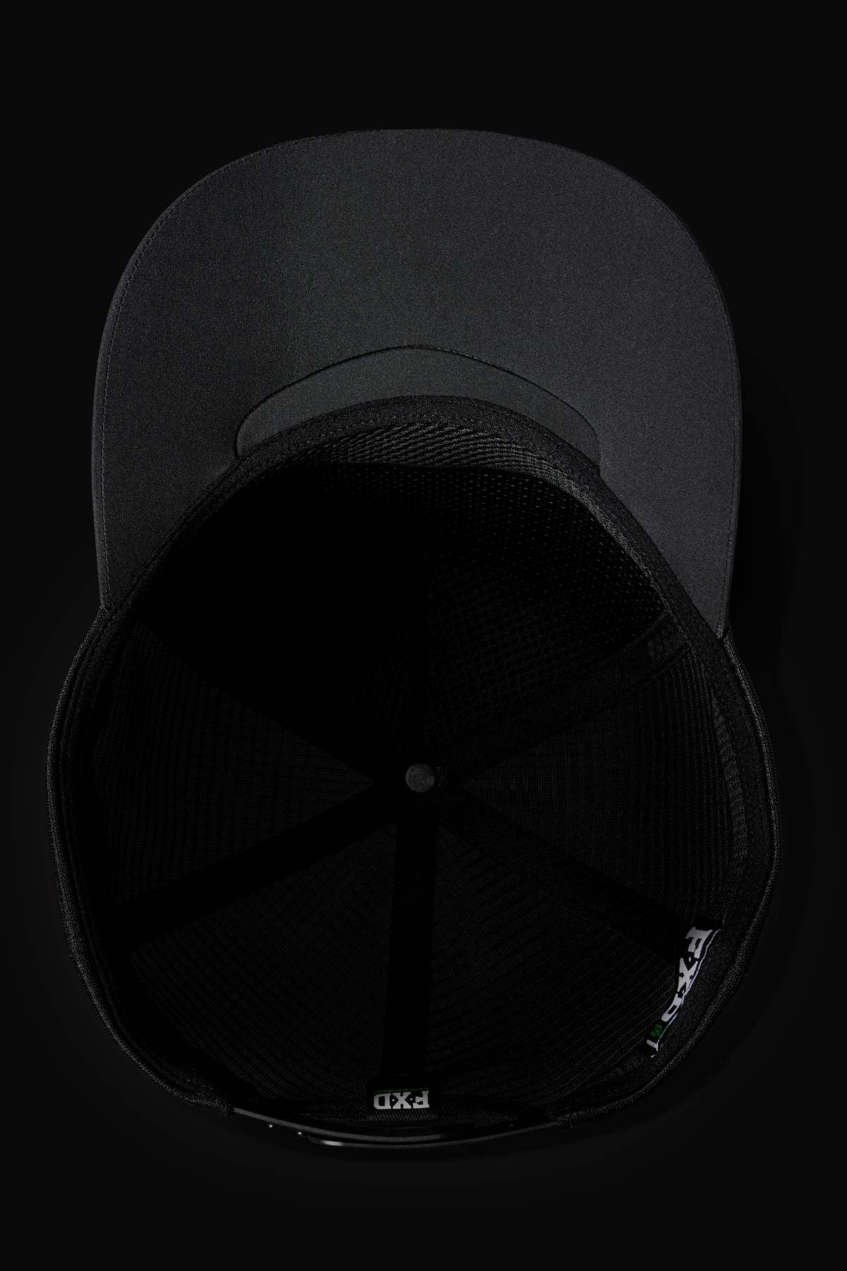 Top-down view of the FXD CP-13 Trucker Cap with a flat brim, breathable mesh interior, and adjustable snap-back strap, displayed against a dark background.