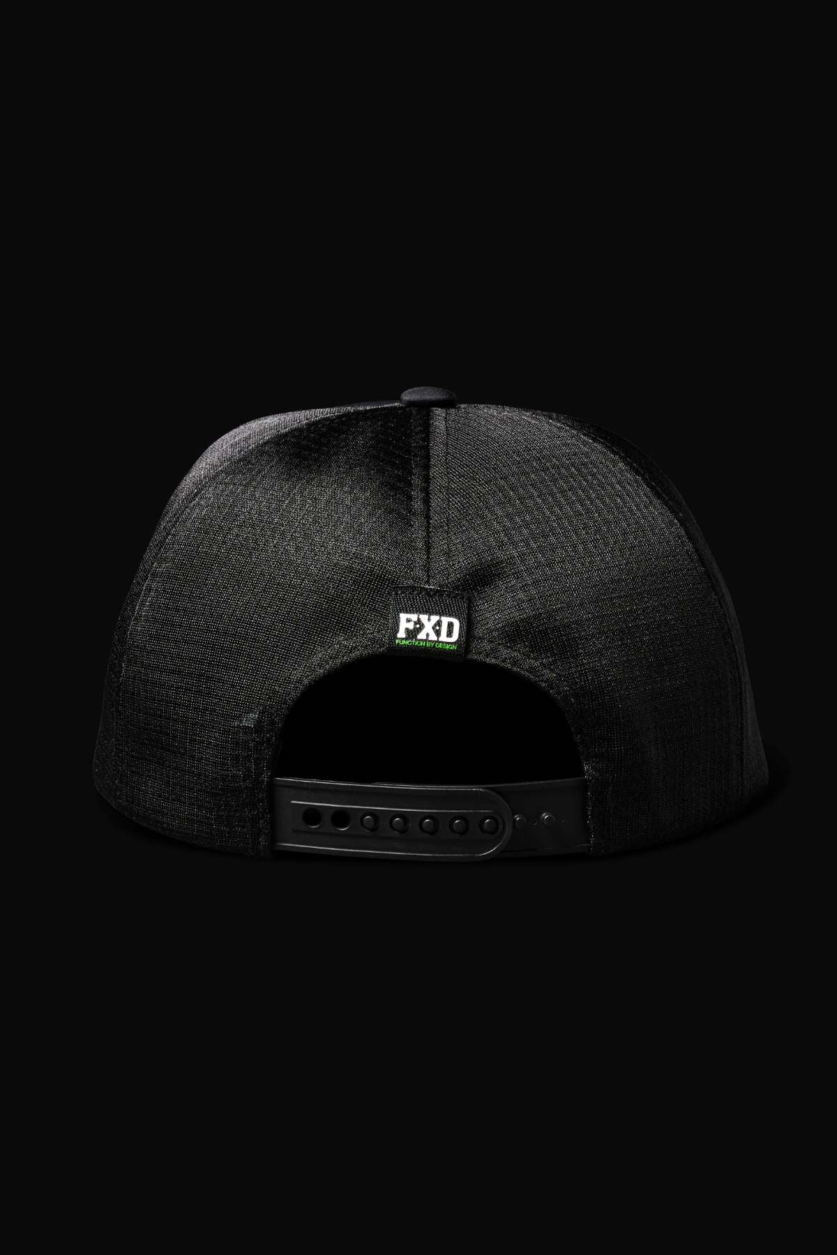 Back view of the FXD CP-13 Trucker Cap shows its breathable mesh, adjustable snap-back strap, and a small green and white FXD logo above the opening, all set against a black background.