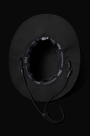 The FXD CP-14 Boonie Hat, shown from above against a dark background, is black with lightweight construction, ventilation eyelets, an inner band labeled "FXD," and an adjustable chin strap for sun protection.
