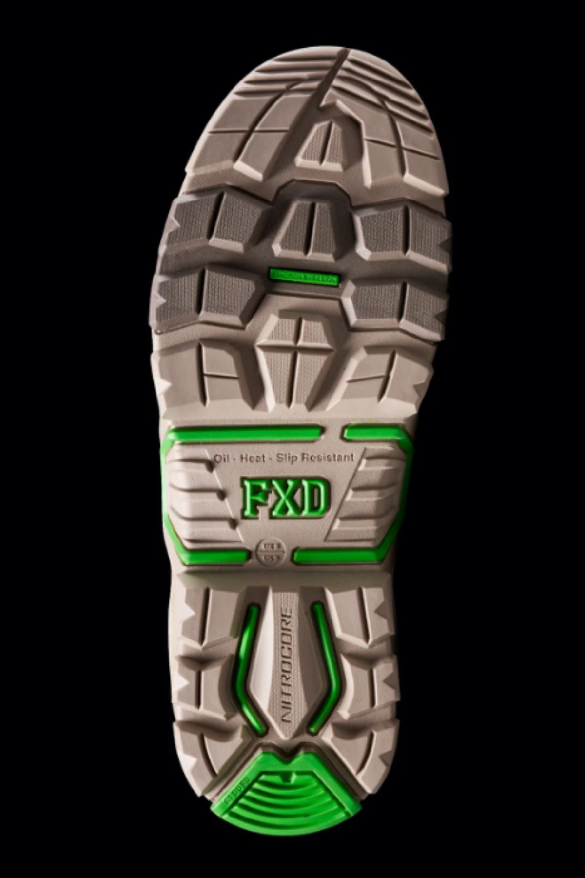 The image displays the sole of FXD DURA X-3 Slip On Work Boots with bold grey tread and green accents. “FXD,” “NITROCORE,” and “Oil • Heat • Slip Resistant” are labeled. The background is black.