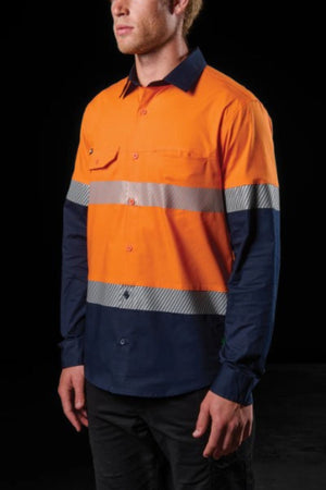 Wearing the FXD LSH-4T Work Shirt—a durable stretch hi-vis shirt with an orange top, navy blue bottom, and two reflective silver stripes—a person stands against a black background.