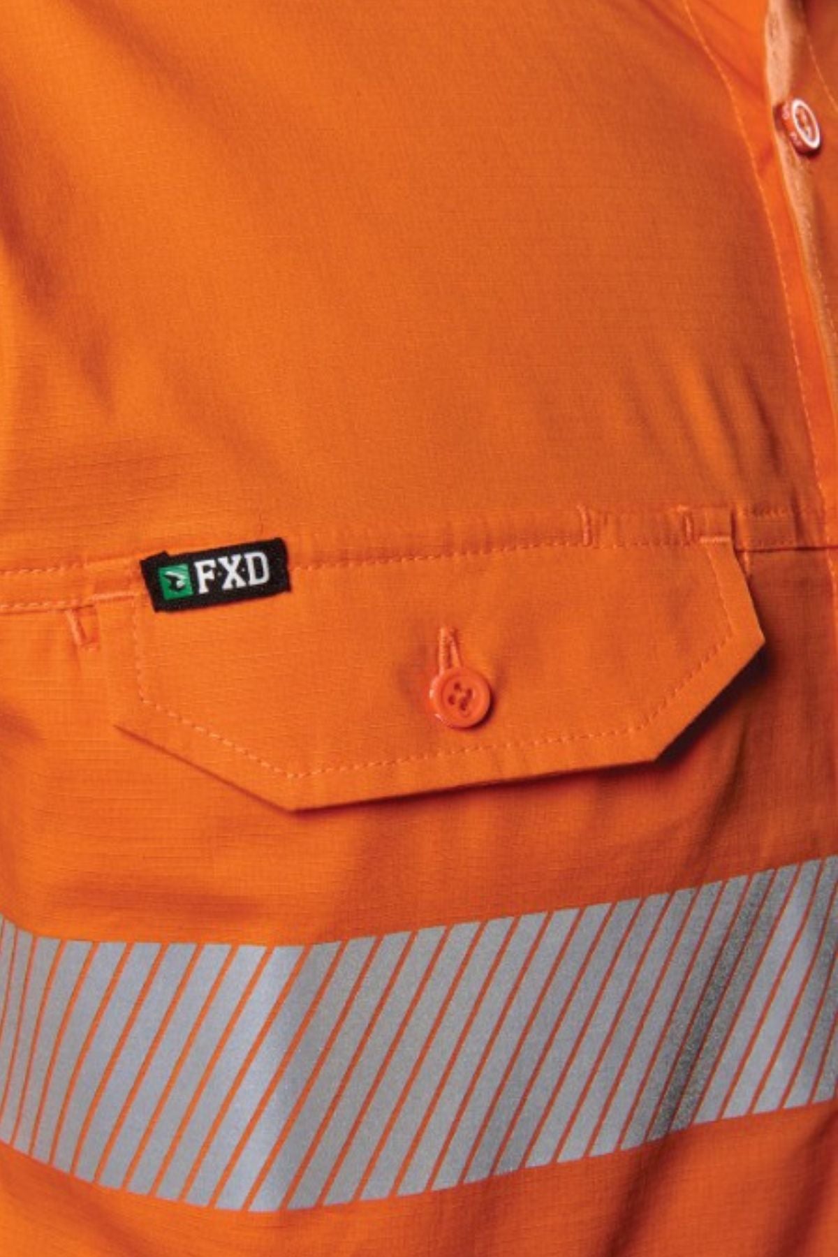 Close-up of the FXD LSH-4T Work Shirt in orange featuring a buttoned pocket, reflective silver stripes, and a small black and green FXD label above the pocket.