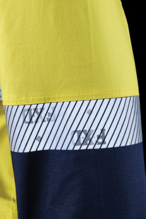 A close-up of the FXD LSH-4T Work Shirt, showing three sections: bright yellow on top, a white stripe with diagonal black lines and faded text in the center, and dark blue fabric at the bottom.