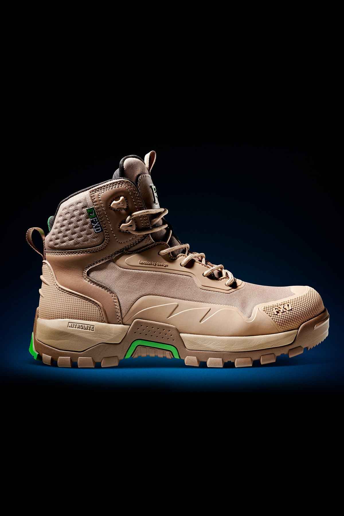 The FXD WB-6 Work Boot is a tan hiking boot with a high ankle collar, durable reinforced stitching, and a rugged rubber sole designed for outdoor activities and rough terrains. It features green accents on the sole and a green tag near the top for added style. Additionally, it includes a PORON heel insert for extra comfort.