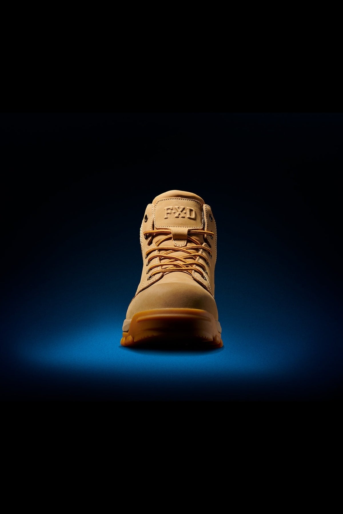 The FXD WB-3 Work Boot is featured on a vivid blue and black gradient background, showcasing its premium leather design. Displayed from the front, the boot highlights its sturdy appearance and safety toe feature with the distinctive FXD logo.