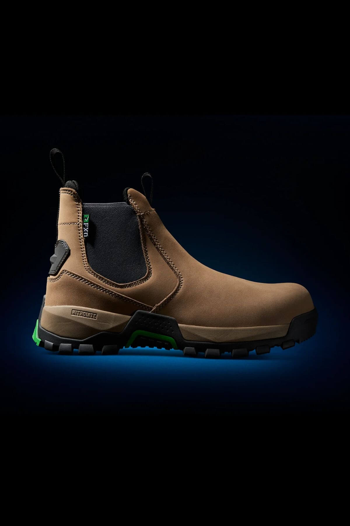 The FXD WB-4 Work Boot features a brown slip-on design with black elastic side panels and pull tabs, complemented by a rugged black sole. Green accents enhance the sole and heel, adding a touch of style. The slip-resistant boot is showcased against a black background with a subtle blue glow.

