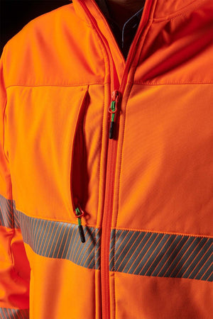 Close-up of a person wearing the FXD WO-3T Hi Vis Soft Shell Work Jacket in bright orange, featuring reflective stripes across the chest and arms. This breathable, wind and water-resistant jacket includes a front zipper and zippered pockets, enhanced with black and green cord pulls for easy access.