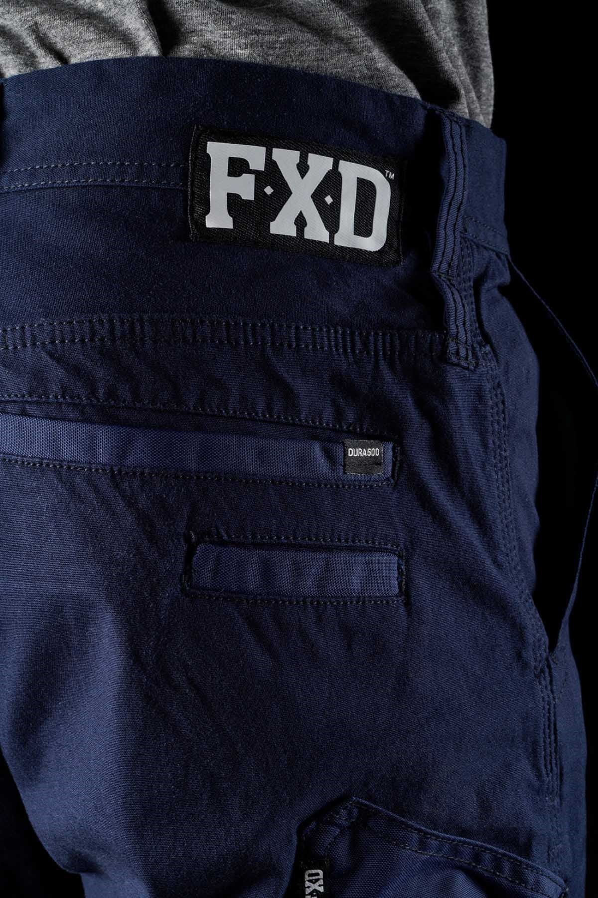 Close-up of the back pocket of dark blue FXD WP-4 Stretch Cuffed Work Pants, highlighting the FXD logo above the pocket and the label "Durable" on the seam. The DURA500™ stretch cotton canvas fabric texture and seam details are clearly visible.