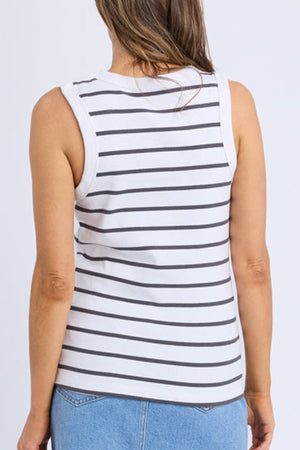 A person with long hair is seen from the back wearing a sleeveless white Foxwood Iris Stripe Tank with horizontal black stripes, paired with light blue jeans, against a plain background.