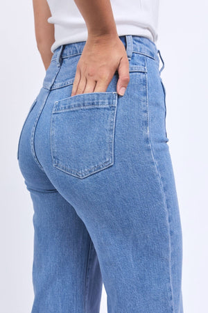 Model in light blue Foxwood Sarah Crop Jeans and a white top, with one hand on the back pocket. Image highlights the jeans' flattering high-rise fit and modern wide-leg style from waist to mid-thigh.