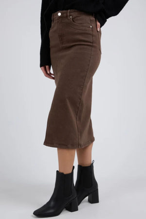 A person wearing the Foxwood Scout Midi Skirt in dark brown, a black top, and black heeled ankle boots stands against a plain light background.