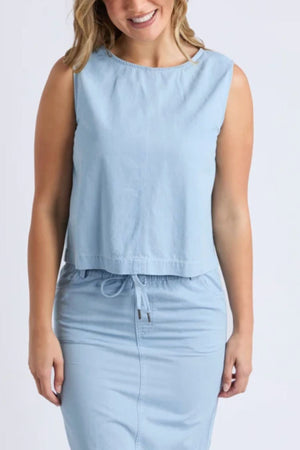 A woman in the Foxwood Zetta Top and a matching drawstring skirt smiles against a plain white background, capturing effortless summer style.