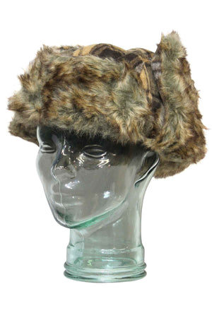 A transparent glass mannequin displays the GUM Artic Trooper trapper hat, featuring ear flaps and a rugged blend of brown and green camouflage, ideal for winter warmth and emphasizing its rugged charm.