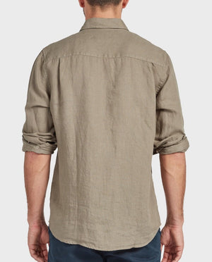 A man, seen from the back with sleeves rolled up, wears the Academy Brand Hampton Linen Shirt and dark blue pants against a plain light background.