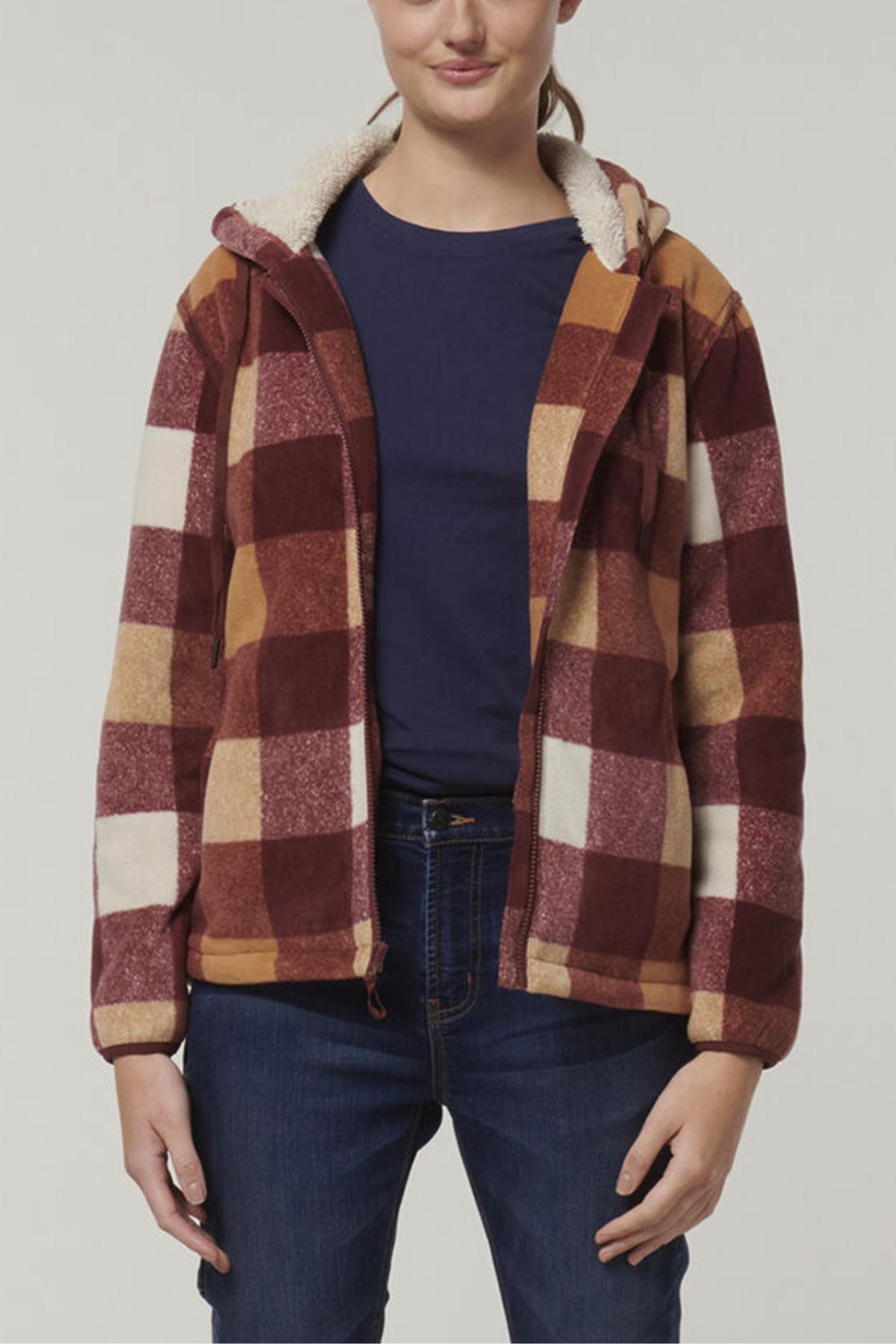 A person wearing a Hard Yakka Womens Check Zoodie with thermal insulation and a bold red, brown, orange, and cream check pattern over a navy shirt and blue jeans stands against a plain background.