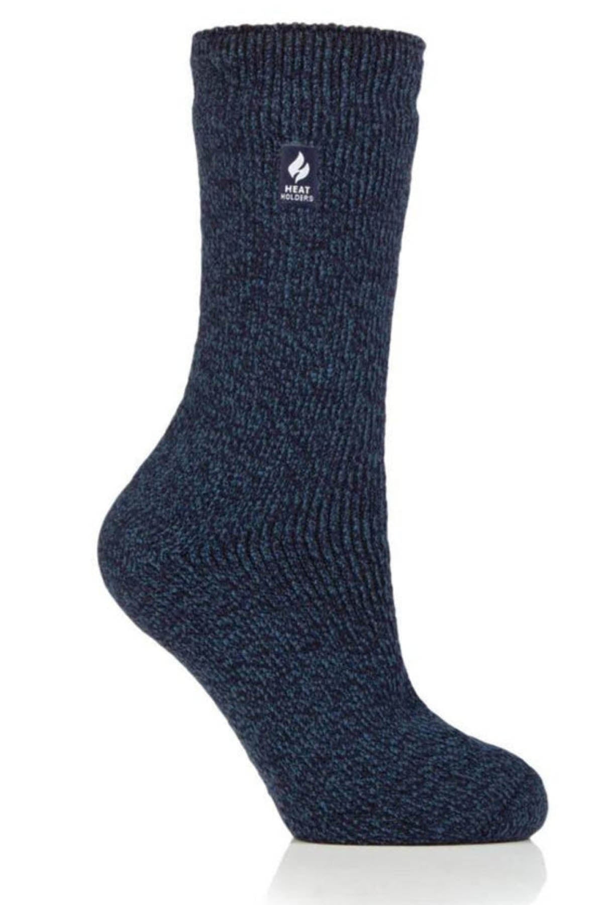 A single Heat Holders Ladies Wool Sock in a dark blue color with a slightly textured knit pattern is displayed on a white background. This warm sock features a small logo near the top, showcasing a flame icon and the text "HEAT HOLDERS" underneath it.