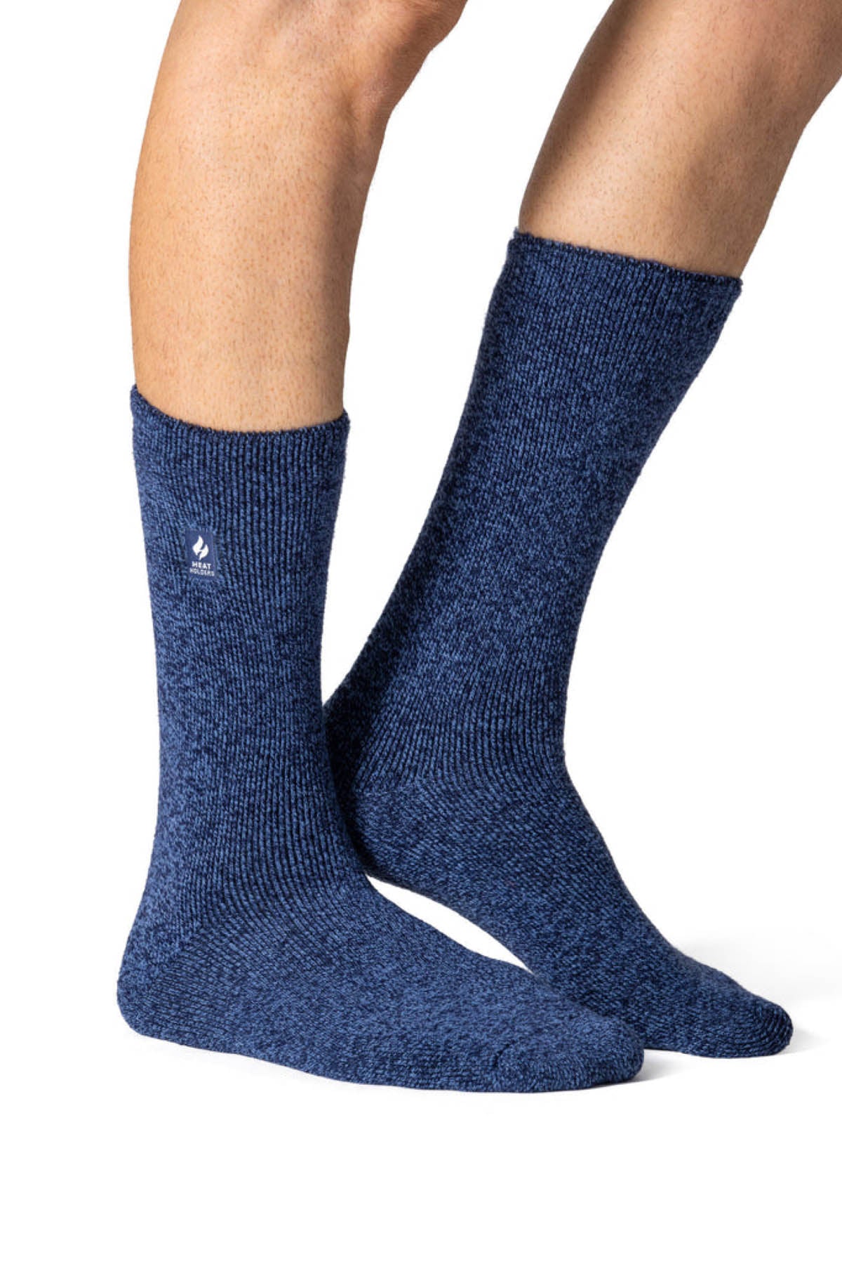 A pair of feet wearing Heat Holders Original Thermal Socks in dark blue with a textured thermal design. These warm, mid-calf winter socks feature a subtle side logo against a plain white background.