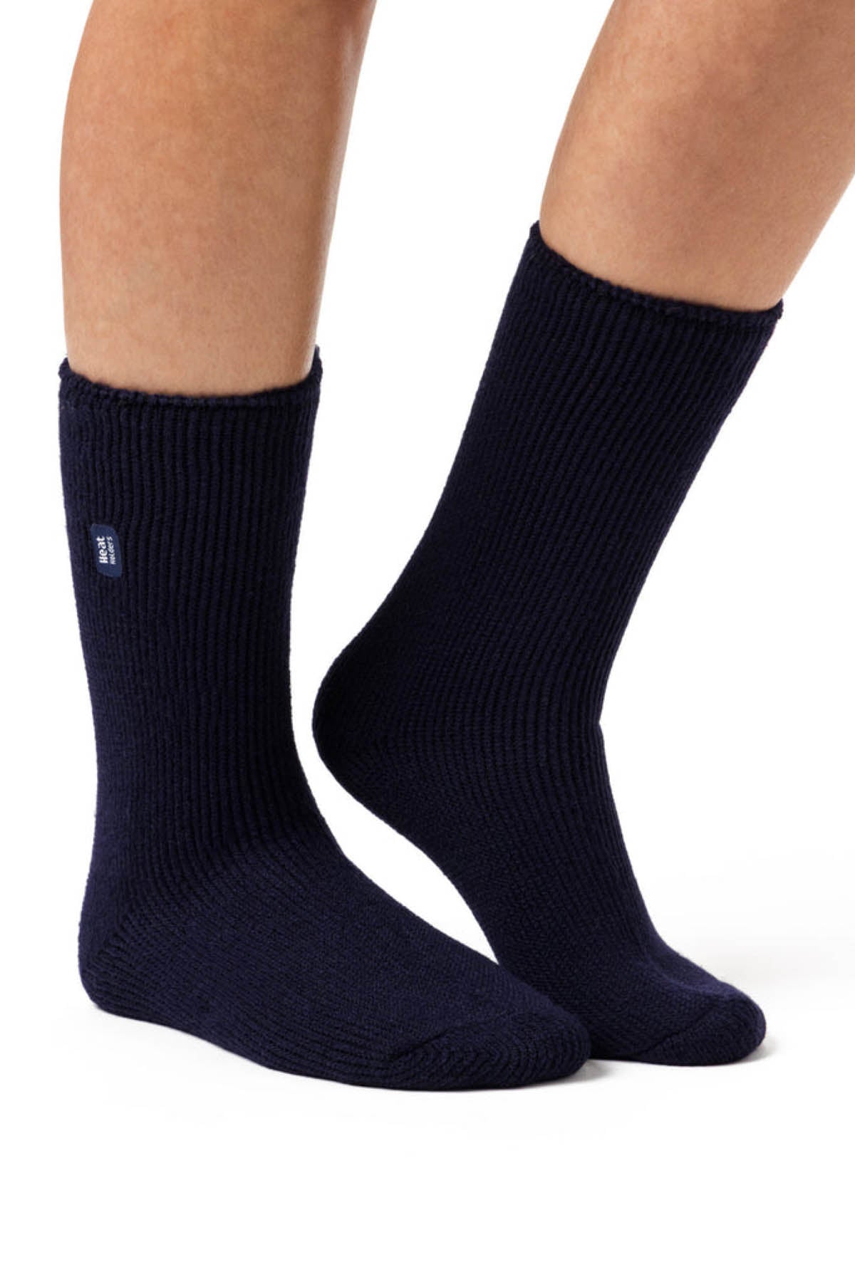 A close-up image of a person wearing a pair of navy blue Original Thermal Heat Holders Socks. The socks extend below the calf, and one sock features a small white logo tag near the top. The plain white background emphasizes the warmth, ideal for cold weather.
