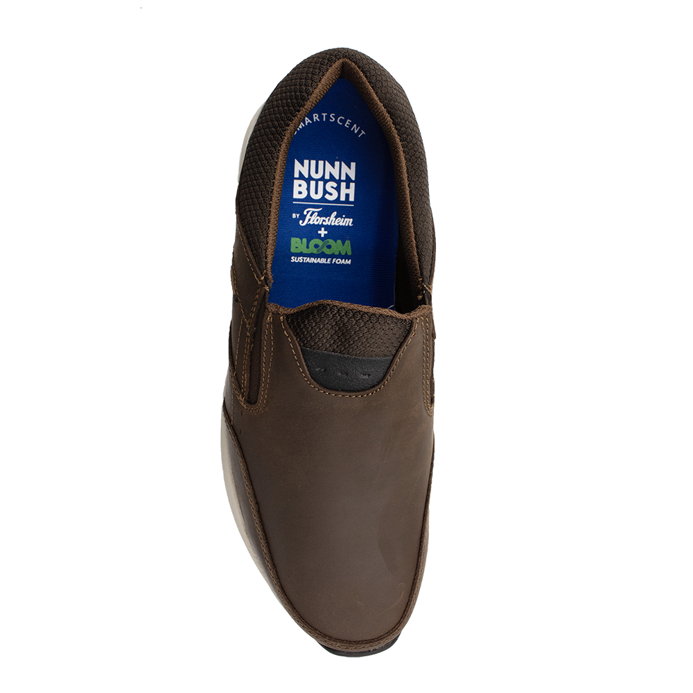 Top view of a brown slip-on shoe with textured fabric around the ankle. The visible insole displays the brand "Florsheim" and mentions sustainable foam designed for optimal shock absorption.