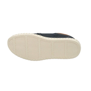 The image presents the sole of the Colorado Texan Shoe, featuring a versatile design with light-colored, textured rubber in zigzag grooves and rectangular sections. The upper surface shows a glimpse of dark nubuck leather nearby.