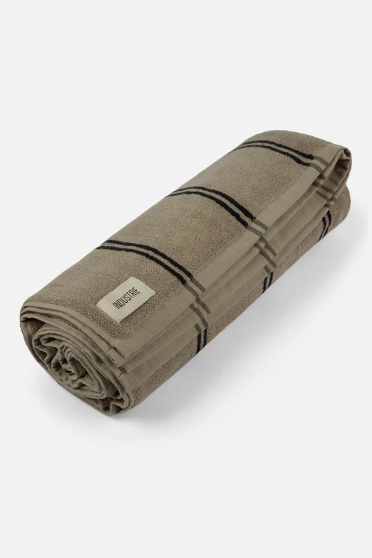 The Industrie The Comporta Beach Towel is a neatly rolled beige cotton terry cloth towel with black plaid stripes and a white "MidoriTec" label on one end, displayed on a plain light background.