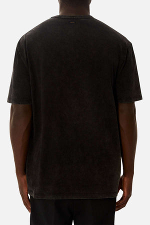 A person wearing the Industrie The Del Sur Acid Wash Tee in black and black pants, shown from the back against a white background.