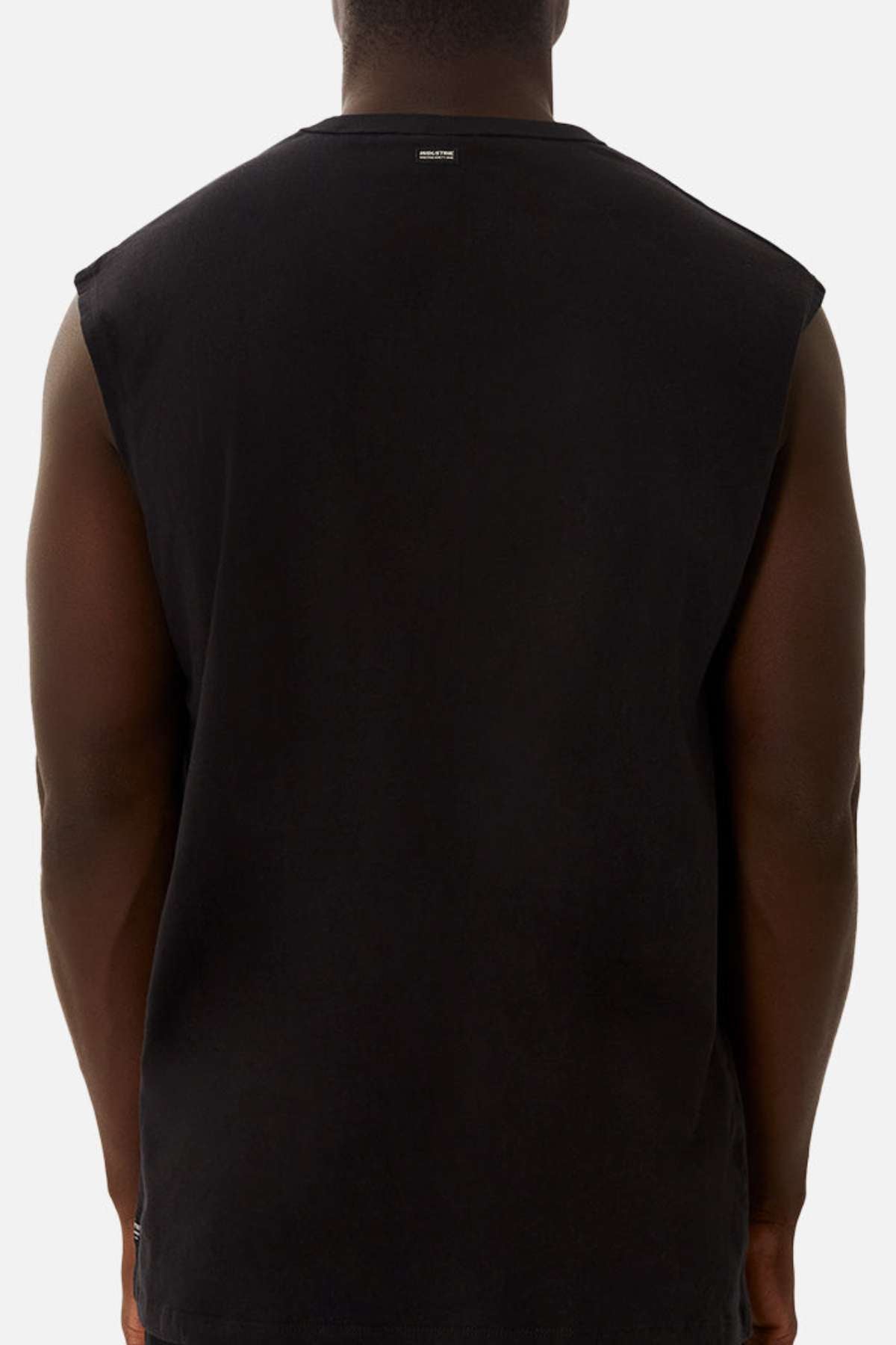 A person is shown from the back, wearing the Industrie The Del Sur Sleeveless Tee in black with an oversized fit against a plain white background. Only their upper body is visible.