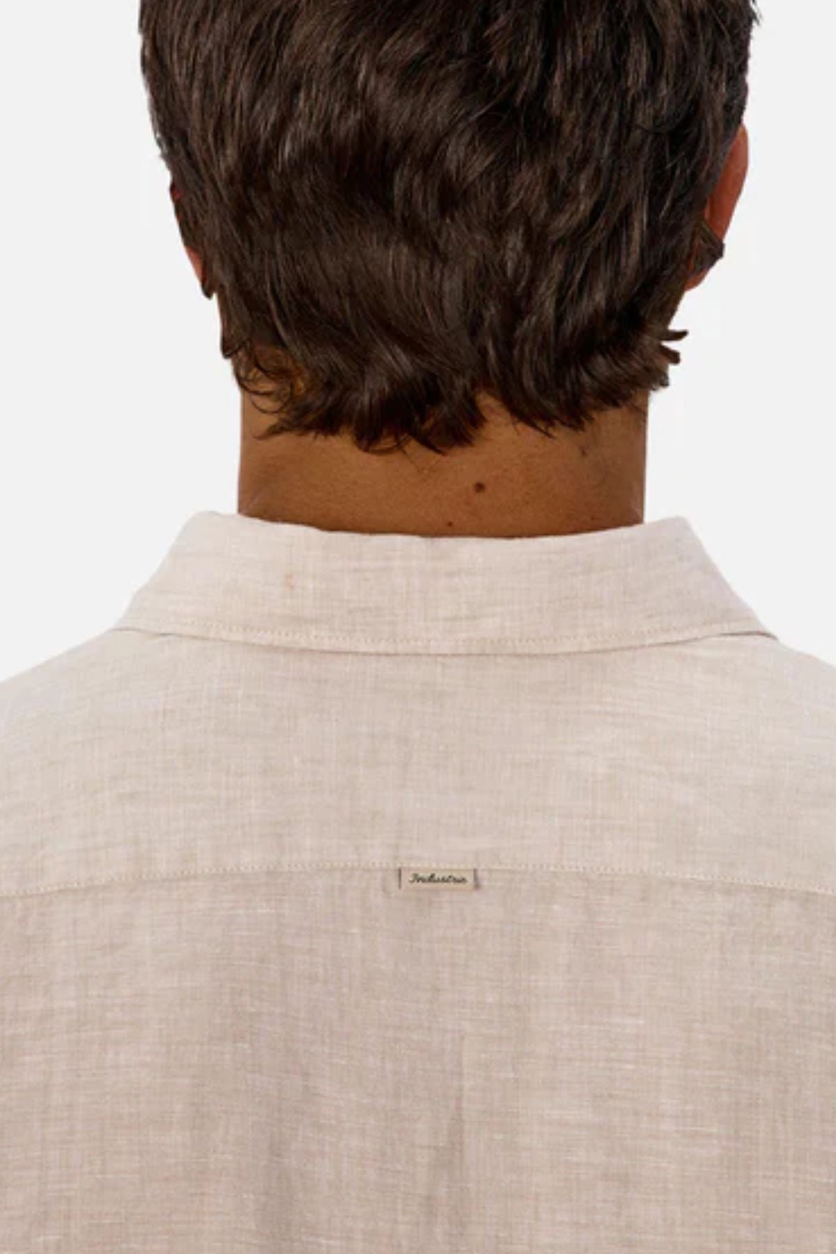 A person with short brown hair is shown from the back wearing the Industrie The St Martins Shirt in light beige, featuring a small text tag at the top center of the back against a plain, light background.