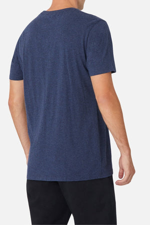 A person is shown from the back wearing the Industrie The Basic Crew Tee in navy blue with a classic fit and black pants, standing against a plain white background.