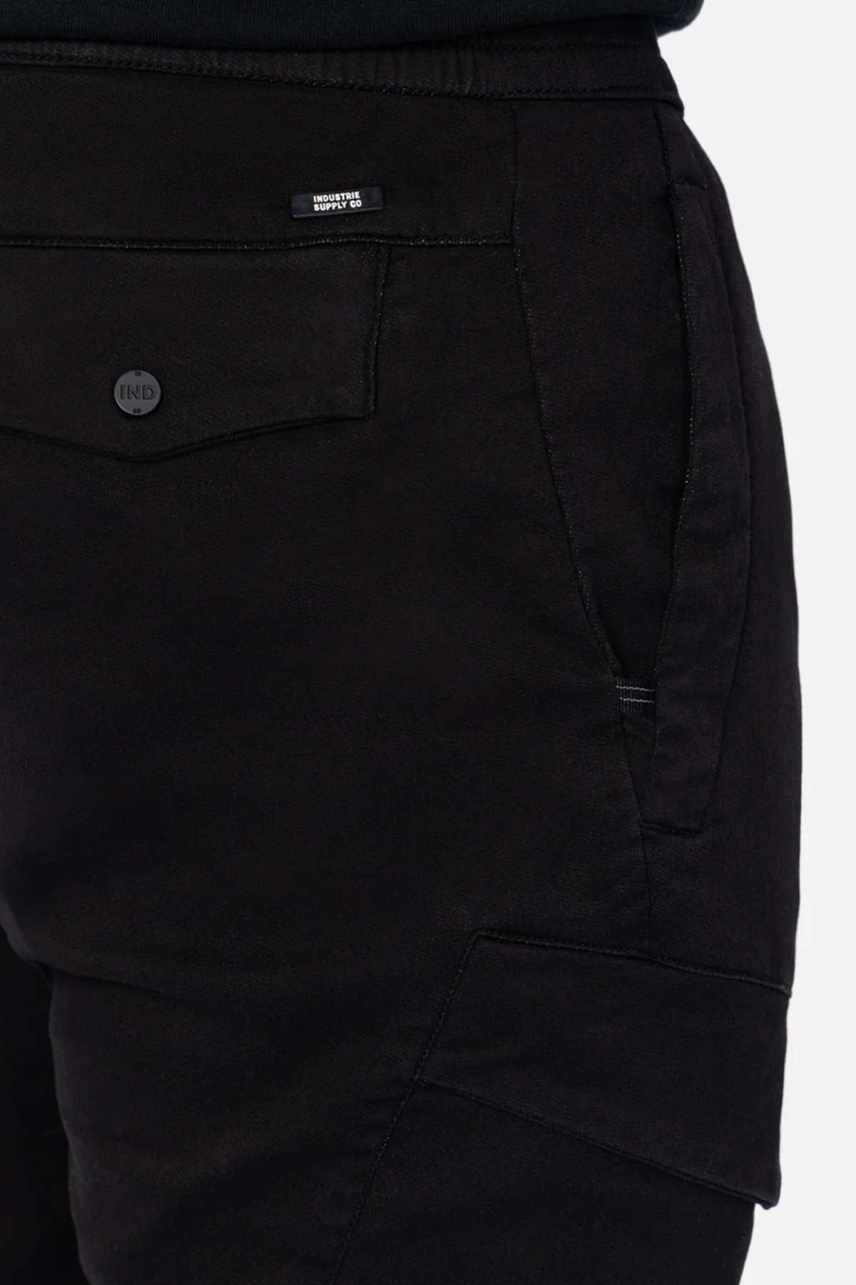 Close-up of Industrie The Defender Combat Pant in black displays detailed side and back pockets with a "BENCH" tag above the back pocket. The textured fabric and prominent stitching suit an active lifestyle, ideal for those on the move.