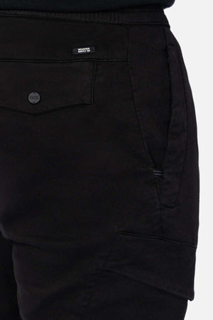 Close-up of Industrie The Defender Combat Pant in black displays detailed side and back pockets with a "BENCH" tag above the back pocket. The textured fabric and prominent stitching suit an active lifestyle, ideal for those on the move.