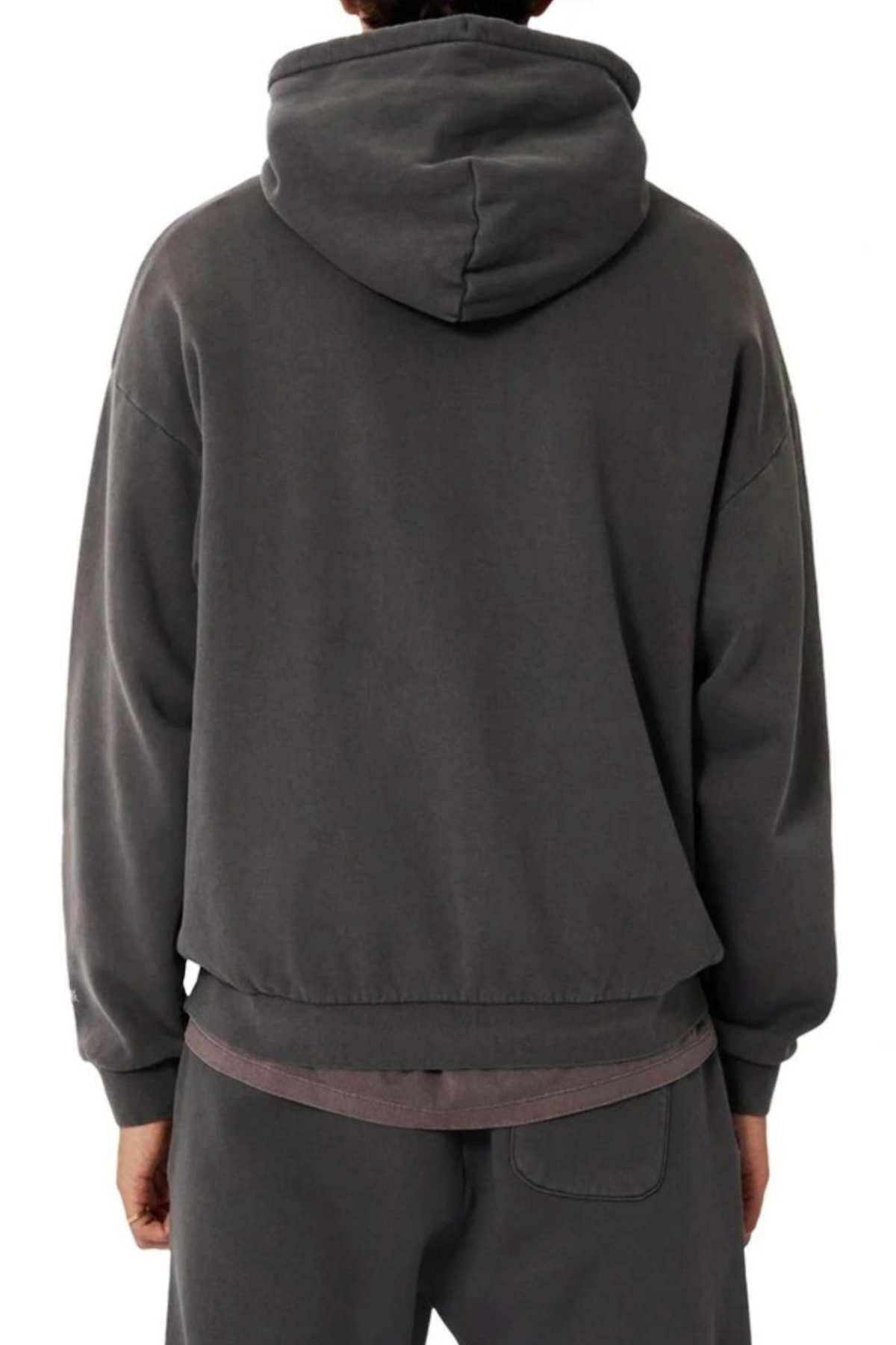 A person is seen from the back wearing an oversized fit, dark gray Industrie The Del Sur Hoodie with matching sweatpants. The hood is up and their hands rest by their sides against a plain white background.