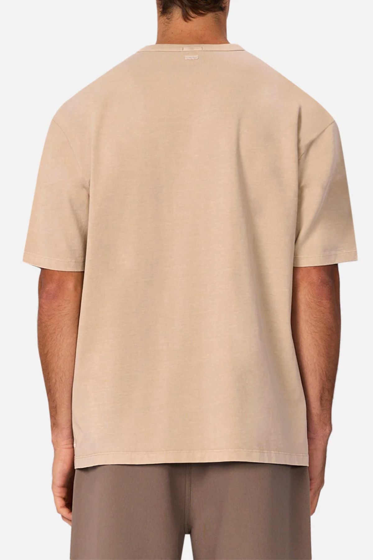 A person is seen from behind wearing the Industrie The Del Sur Tee with an oversized fit, styled with taupe shorts, set against a plain white background.