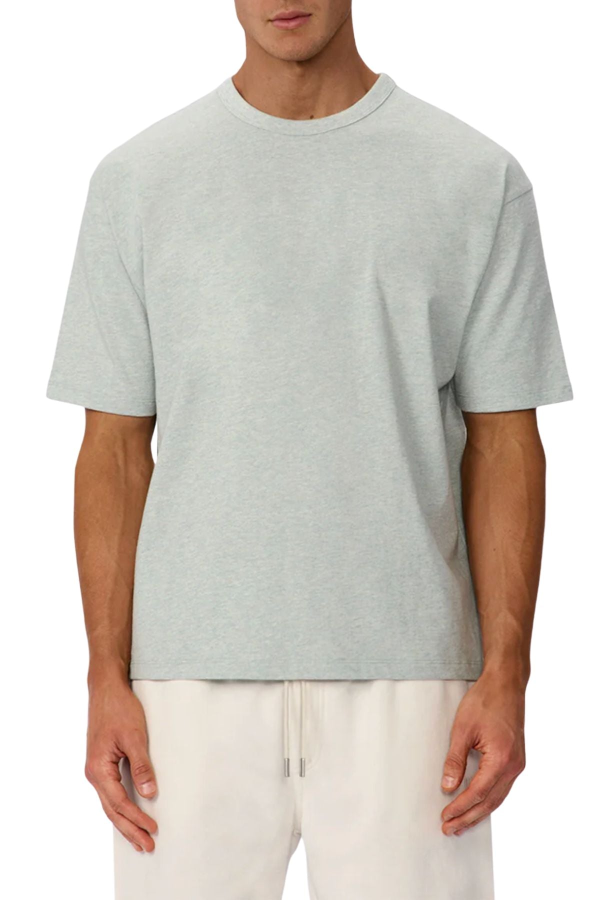 A man wears a light gray, short-sleeve Industrie The Del Sur Tee made from heavyweight fabric and off-white drawstring pants, standing against a plain background.