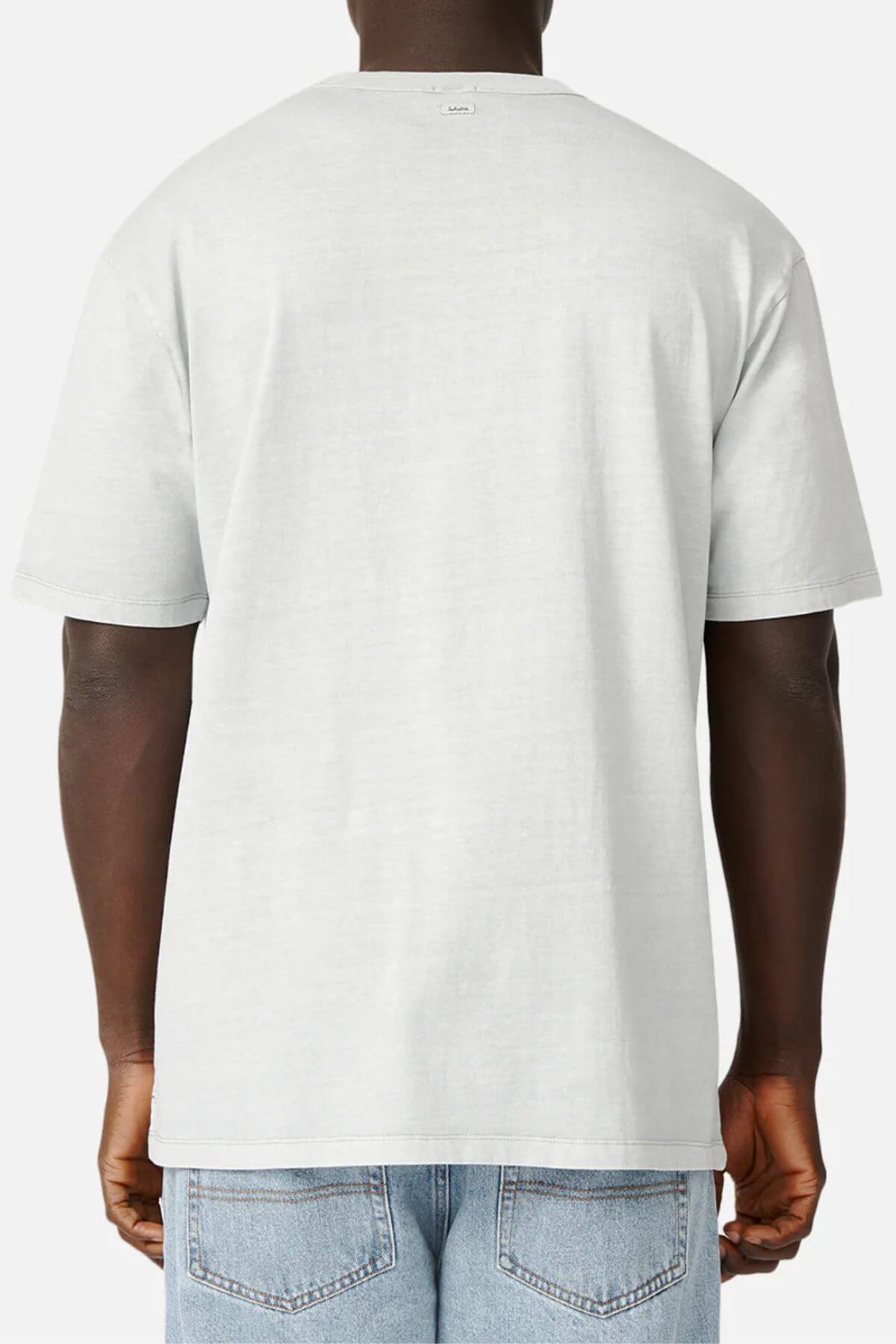 Rear view of a person wearing a light gray Industrie The Del Sur Tee in 100% cotton and blue jeans. The oversized fit adds comfort, and the tee features a small tag near the neckline. Their hands are relaxed by their sides against a plain white background.