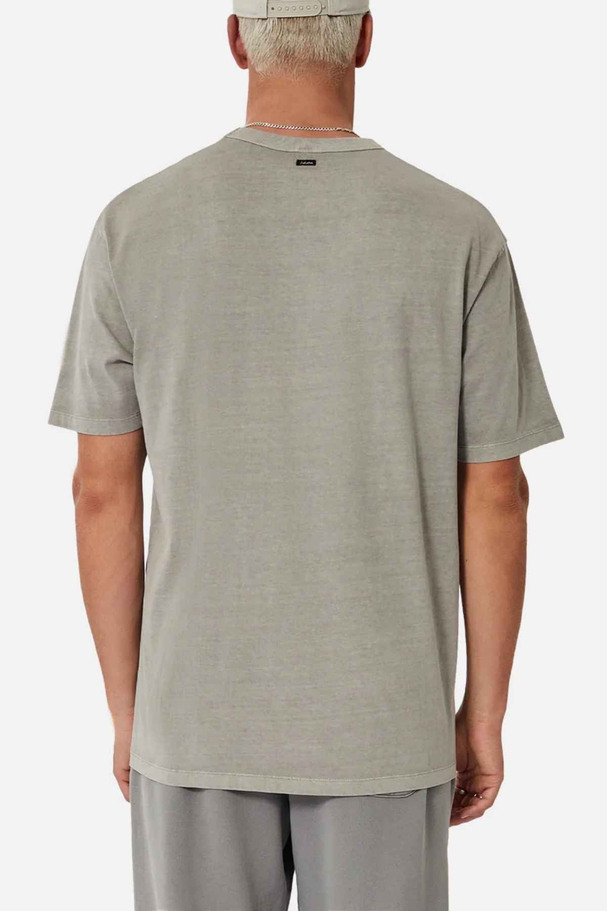 A person with short hair is wearing the Industrie The Del Sur Tee, which is oversized and made of 100% cotton, alongside matching acid wash shorts and a cap, all while facing away from the camera against a plain white background.