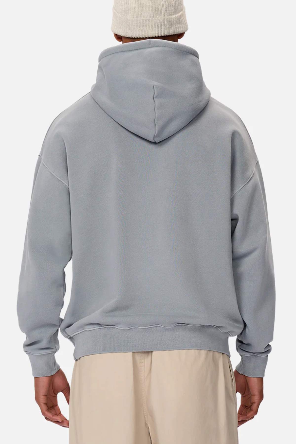 Someone wearing the Industrie The Del Sur Washed Hoodie in light gray with an oversized fit and beige pants, viewed from behind, standing against a plain white background.
