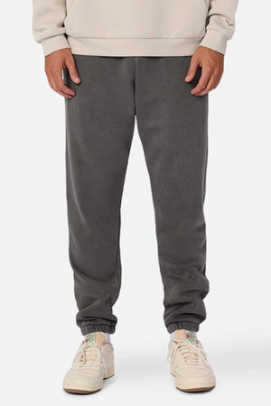 A person wearing a beige sweatshirt, Industrie The Del Sur Washed Track Pant with an elasticated drawstring waist, and white sneakers stands facing forward. Only the body from shoulders down is visible, with hands relaxed at the sides.