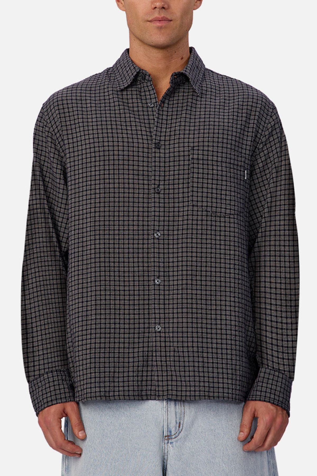 A person wears the Industrie The Diego Long Sleeve Shirt, a regular fit, long sleeve checked shirt in black and gray, paired with light blue jeans, standing against a plain white background.