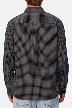 A person is shown from the back wearing the Industrie The Diego Long Sleeve Shirt in a black and gray check pattern, paired with light blue jeans, against a plain background.
