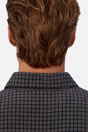 A person with light brown, wavy hair is shown from behind wearing the Industrie The Diego Long Sleeve Shirt, a regular fit checked shirt, against a plain white background.