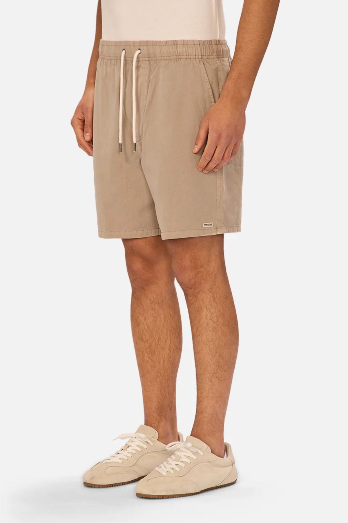 Someone models the Industrie The Dublin Short in light beige with an elastic waist, paired with a cream top and beige sneakers. Styled against a plain white background, this casual outfit is comfortable and ideal for everyday wear.