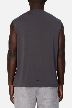 A person is shown from the back wearing the Industrie The Freeman Sleeveless Tee in dark gray, paired with light gray shorts, standing against a plain white background.