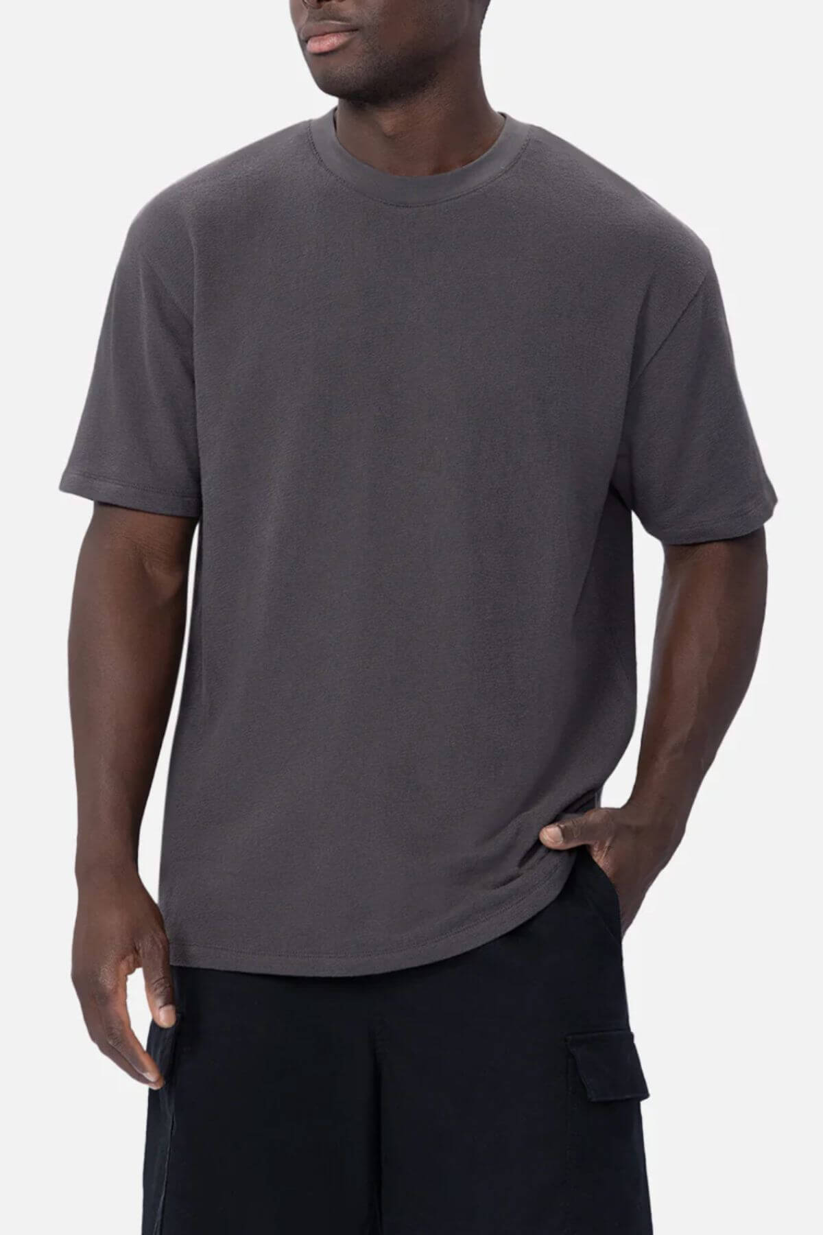 A man wearing the Industrie The Henderson Boucle Tee in dark gray and black cargo shorts stands against a plain light background.